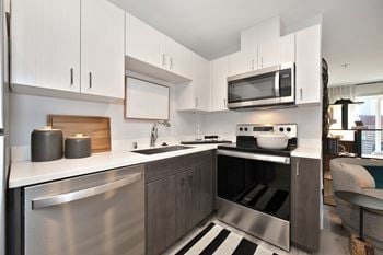 A modern kitchen with stainless steel appliances and white cabinets